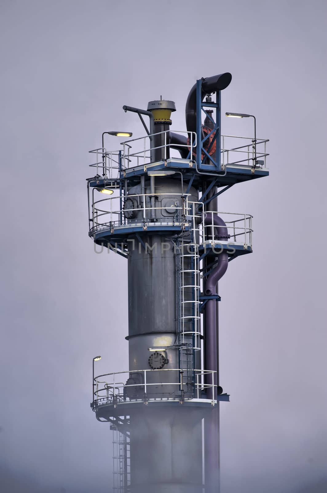 Industrial tower ermerging from clouds of steam.