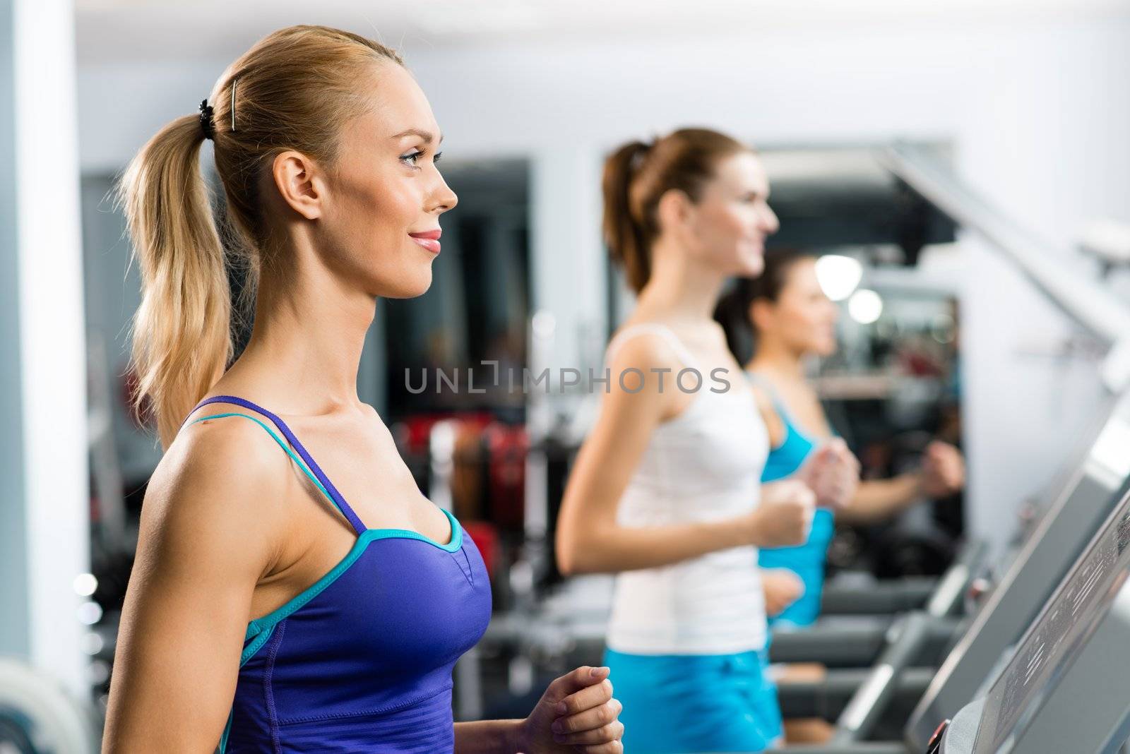 women running on a treadmill in a fitness club, sport in the fitness club