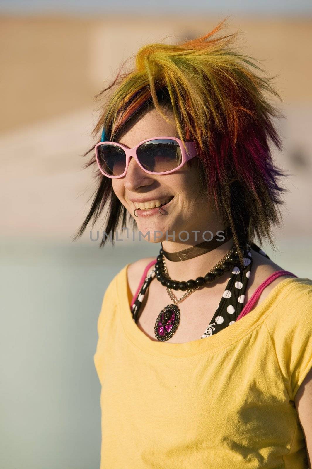 Portrait of a Smiling Punk Girl with Bright Colorful and Big Sunglasses Outdoors at Sundown