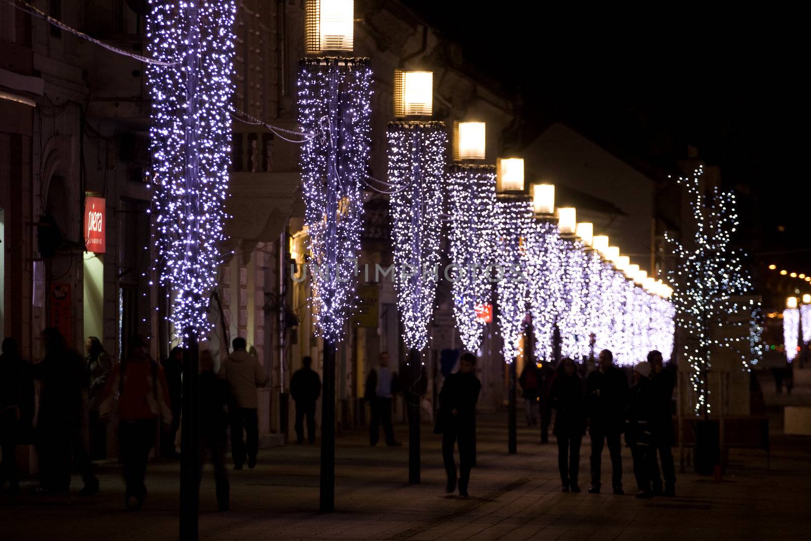 People walking along a row of lights
