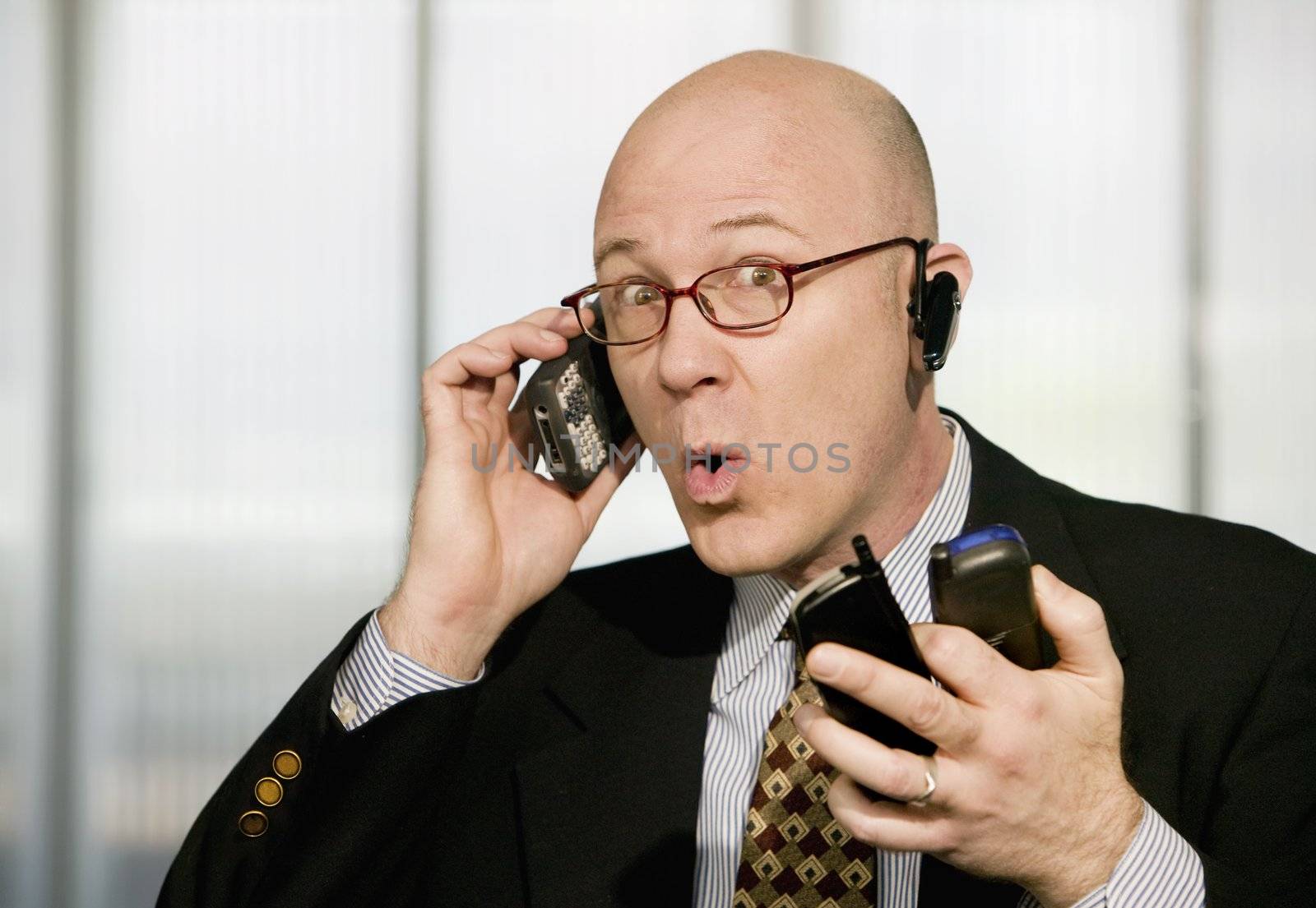 Portrait of businessman with sevral cell phones