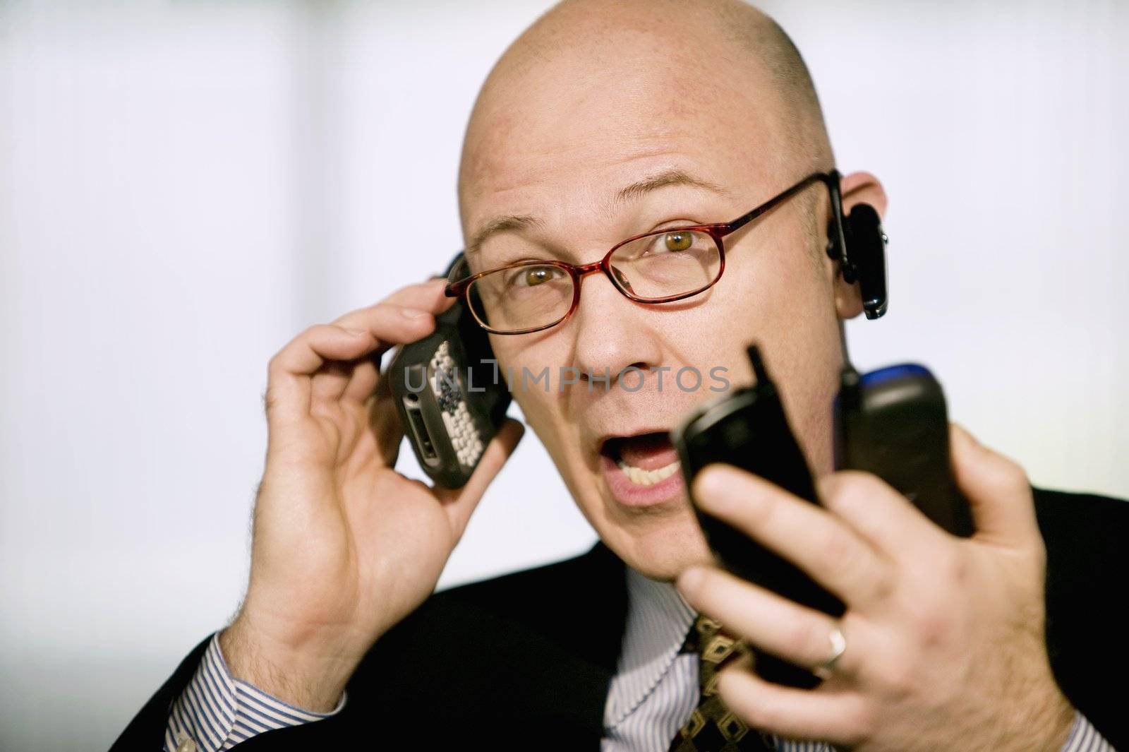 Portrait of businessman with several cell phones