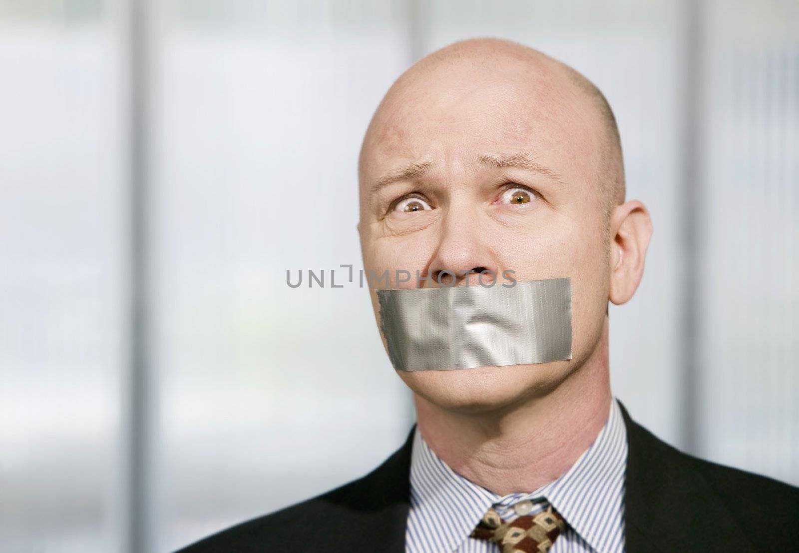 Worried businessman silenced with duct tape over his mouth