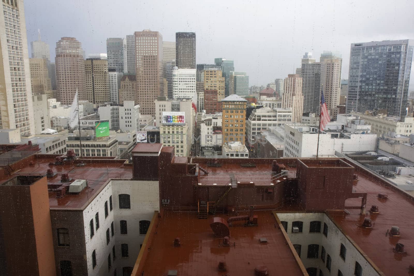 San Francisco cityscape during rain - window view above the roof of old towers of  Westin St Francis Hotel toward Union Square