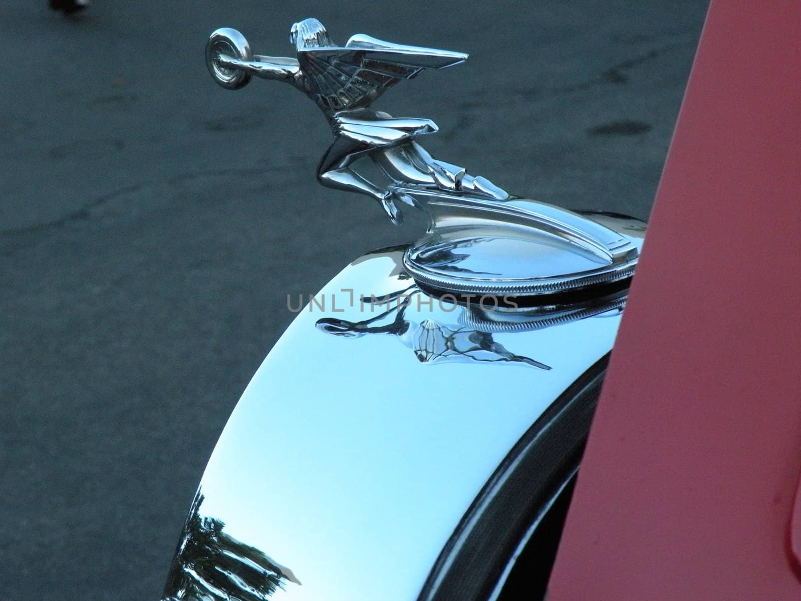 A vintage hood ornament on a restored car