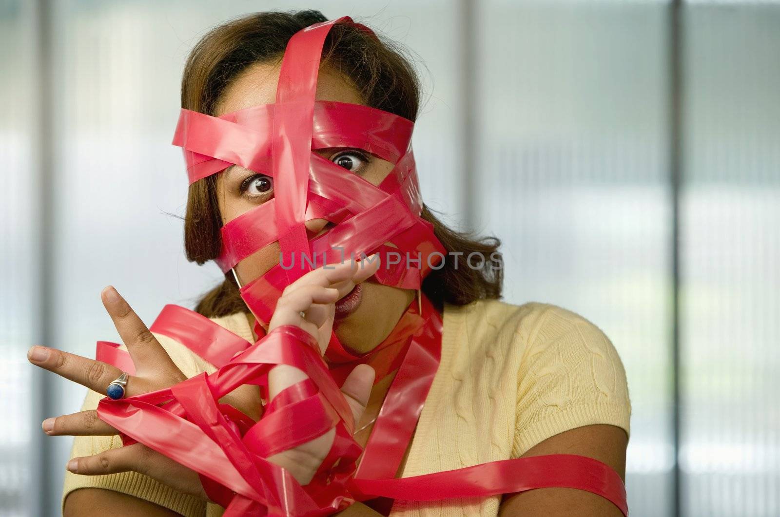 Businesswoman wrapped in red tape