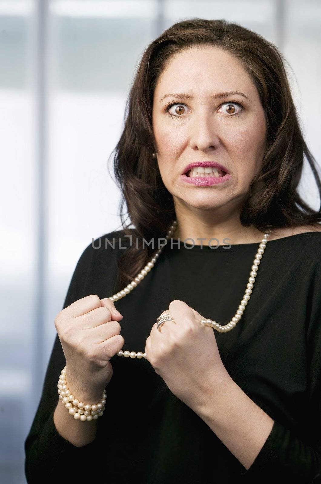 Frustrated Hispanic Woman Pulling on Her Necklace