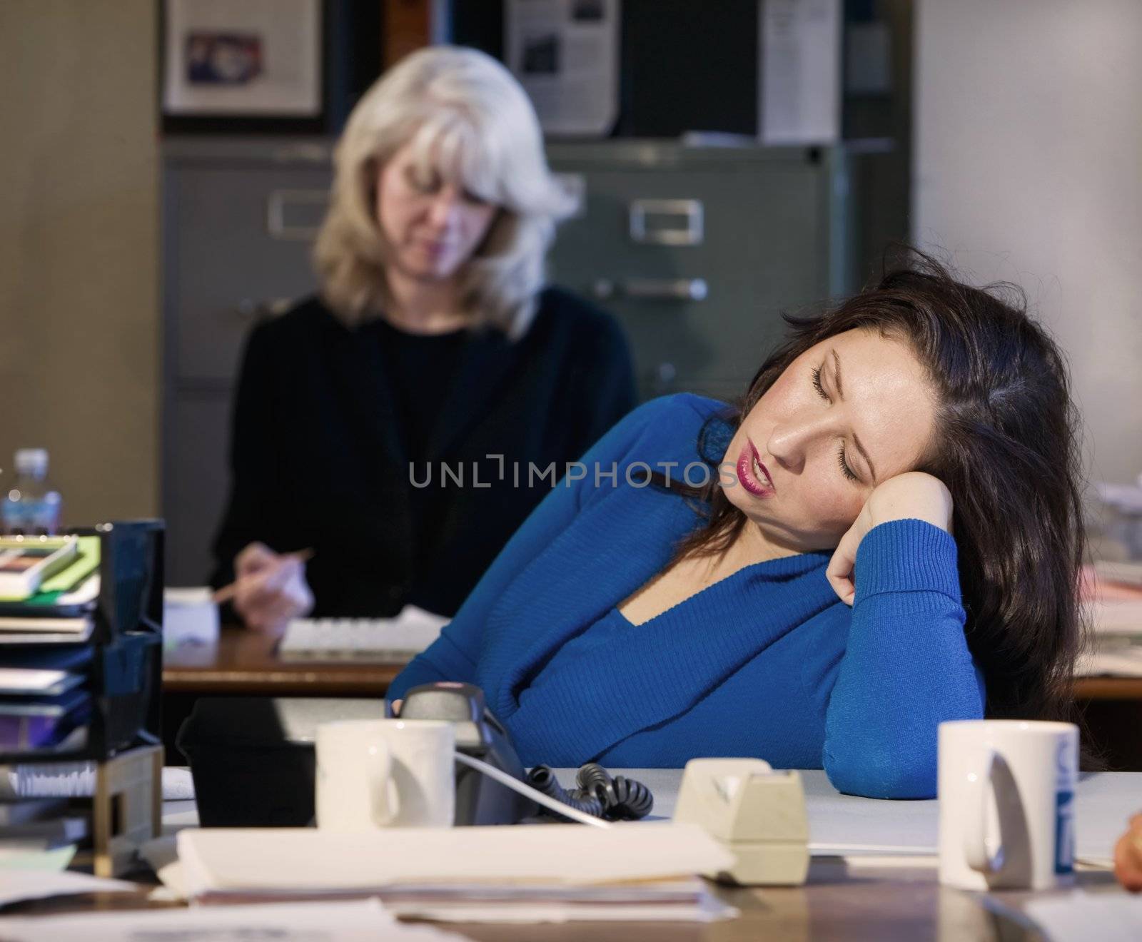 Hispanic woman sleeps at her office desk