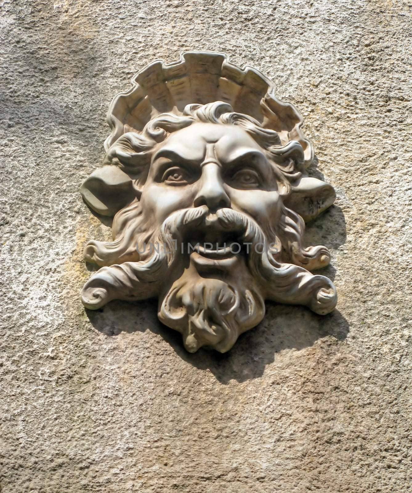 A wall with a stone face on it.