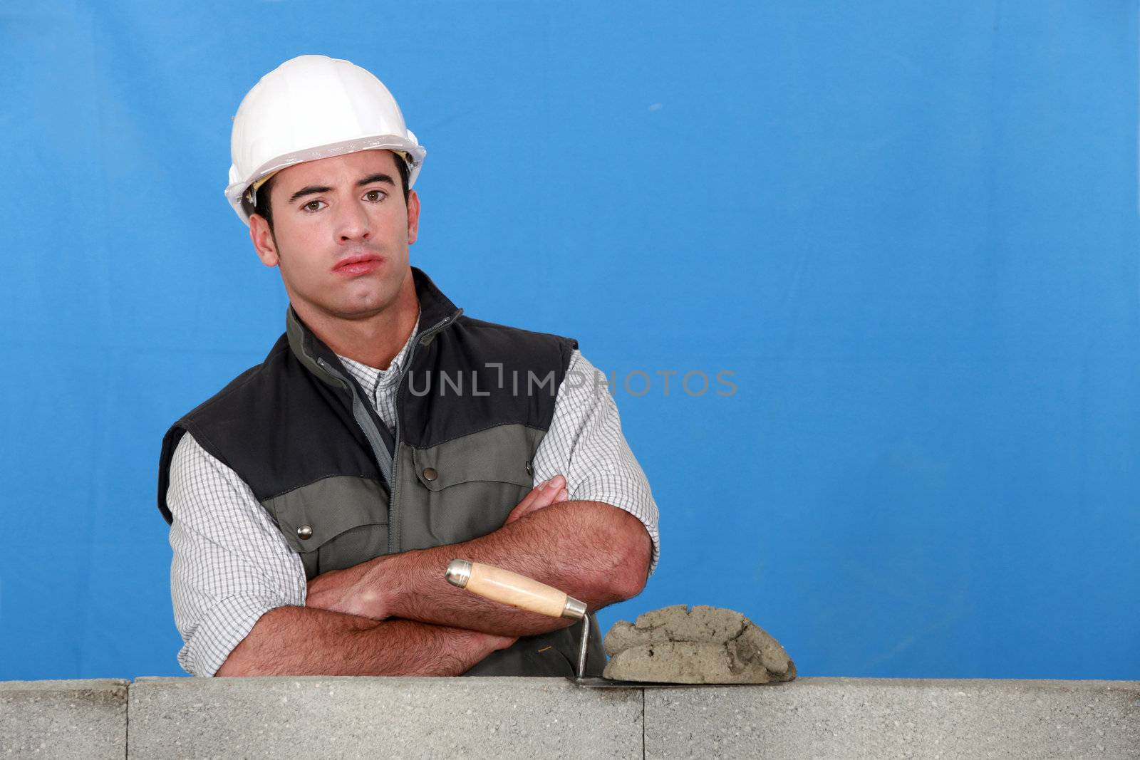 Bricklayer with a block wall by phovoir