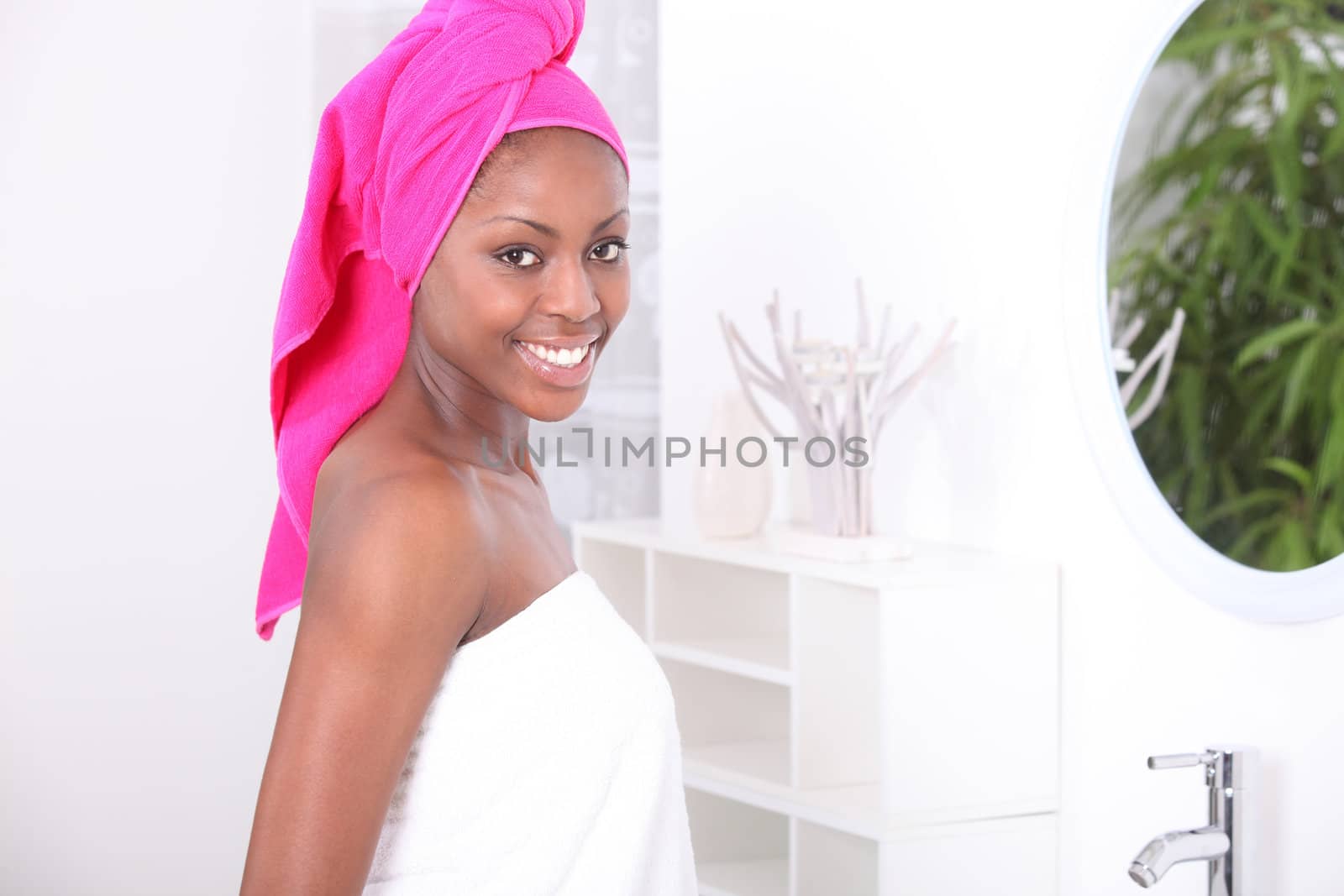 Woman stood in bathroom wearing towel by phovoir