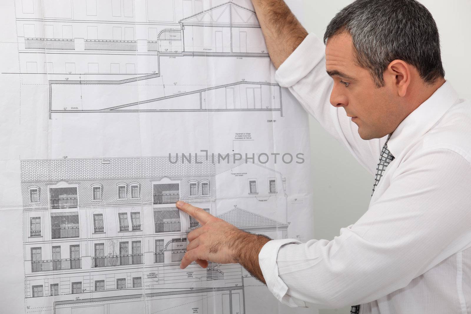 Architect examining a blueprint in detail