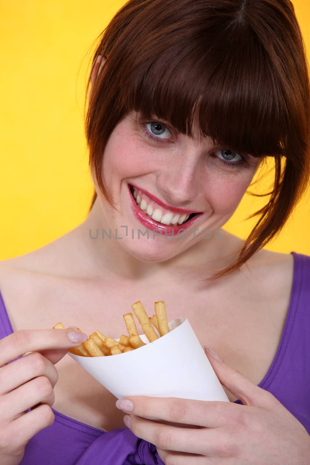 Brunette enjoying French fries.
