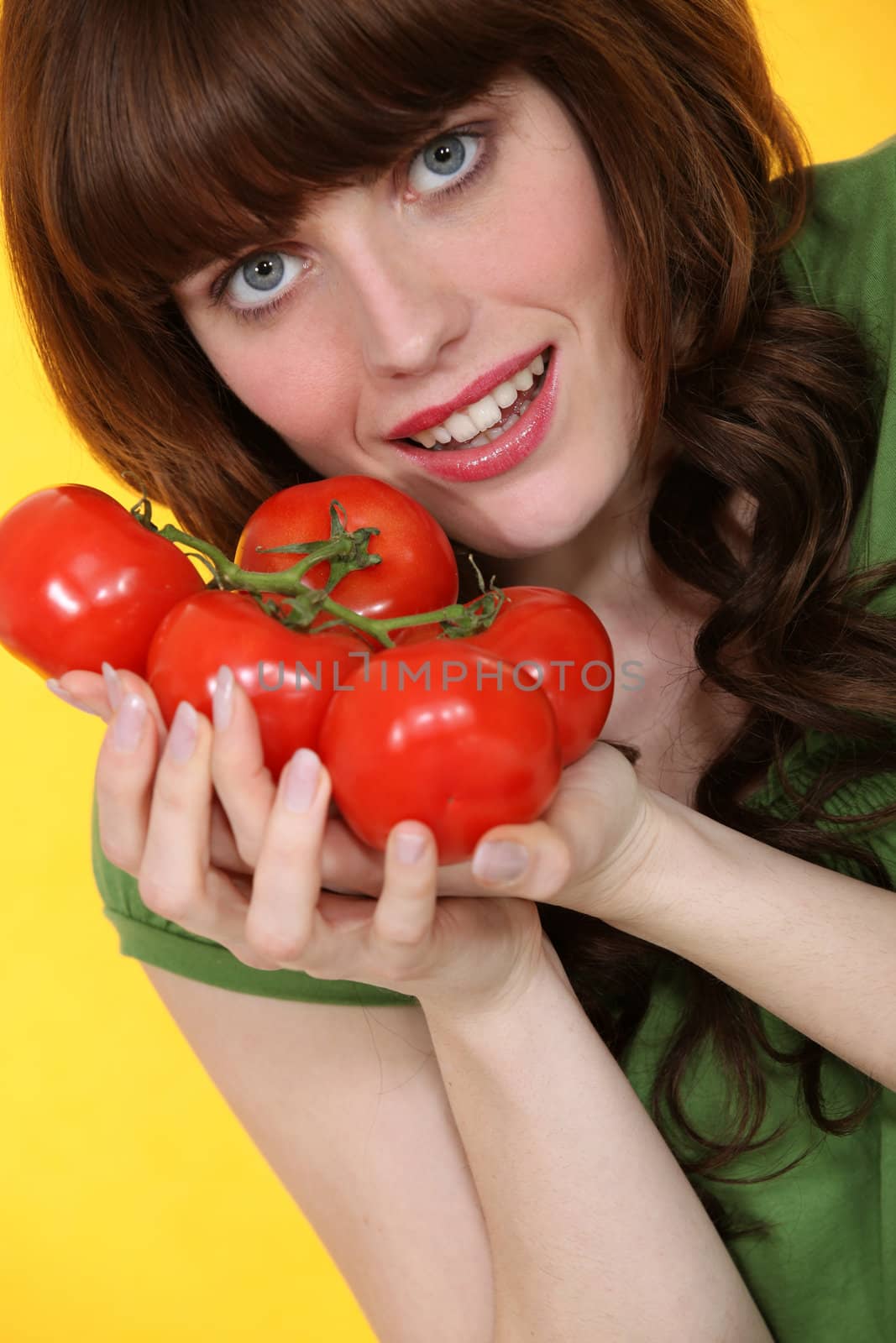 portrait of red-haired girl posing with bunches of tomatoes by phovoir