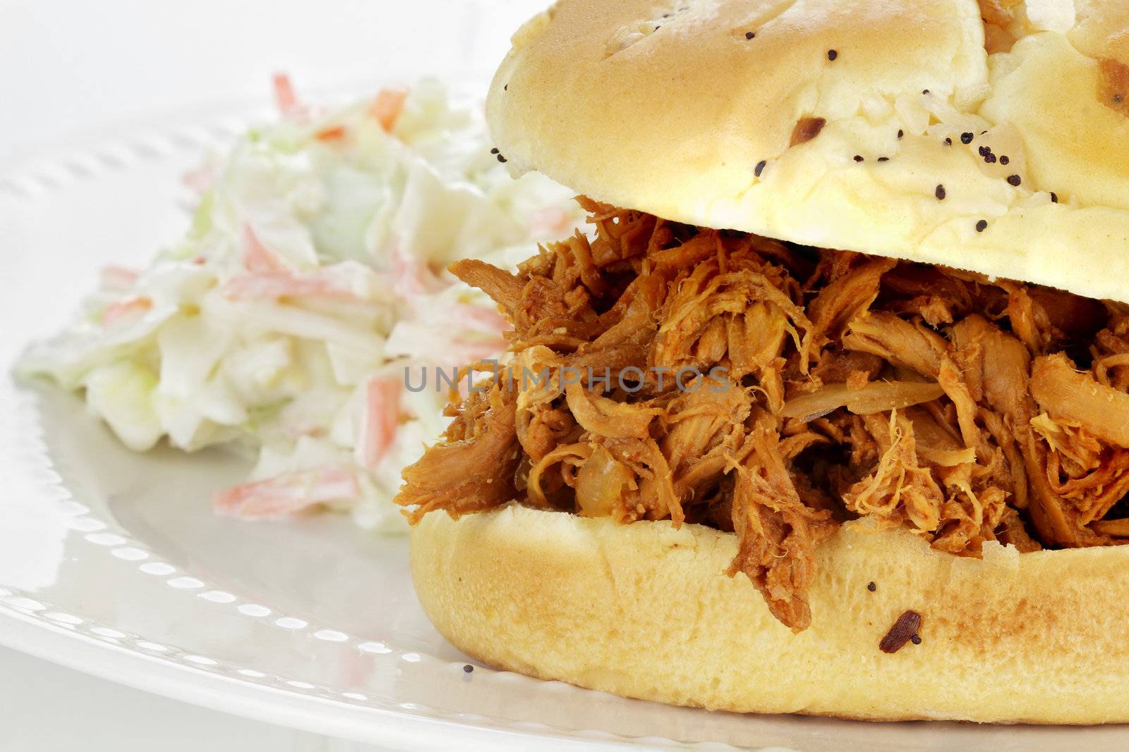 Close up of pulled chicken sandwich with coleslaw. 