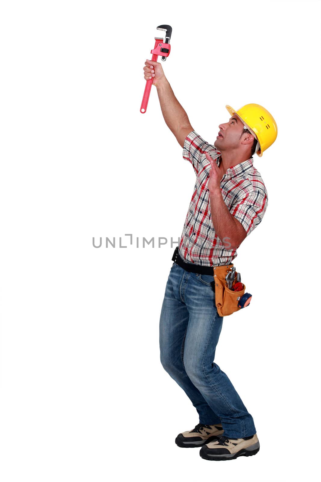 Tradesman using a pipe wrench to tighten an object by phovoir
