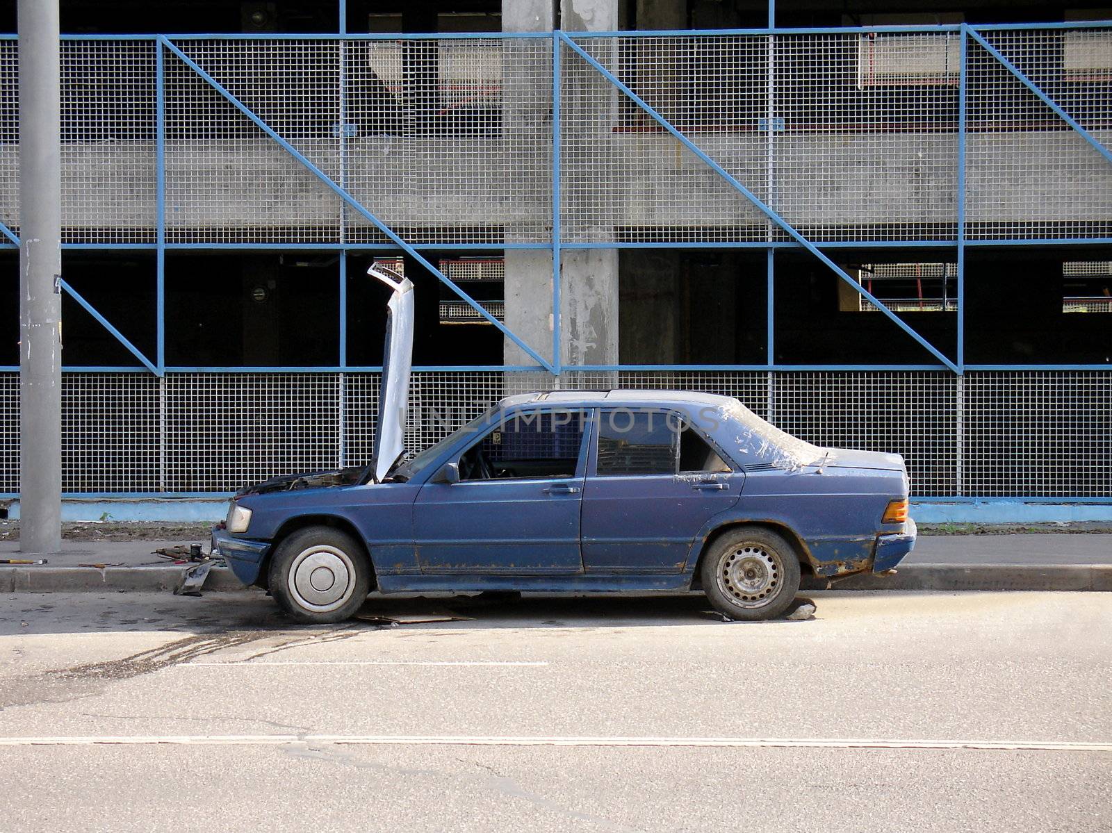 Old Mercedes car under repair outside of the road