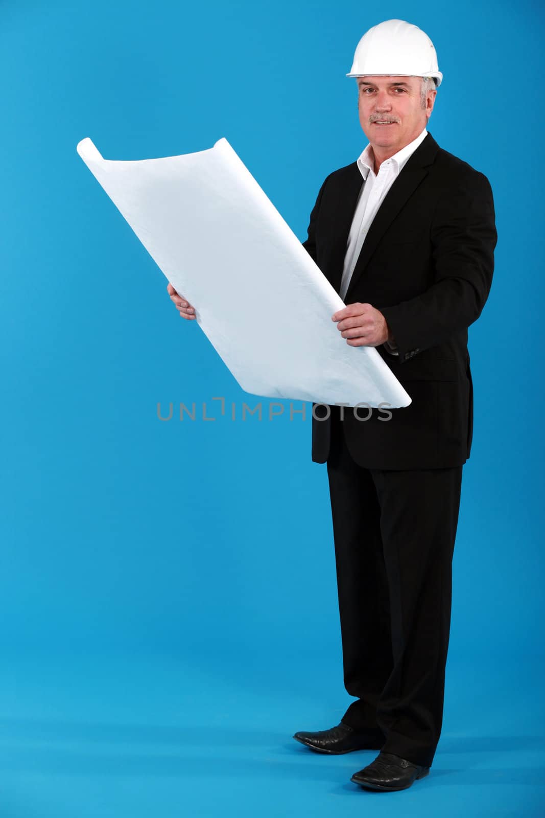 Architect standing on blue background by phovoir