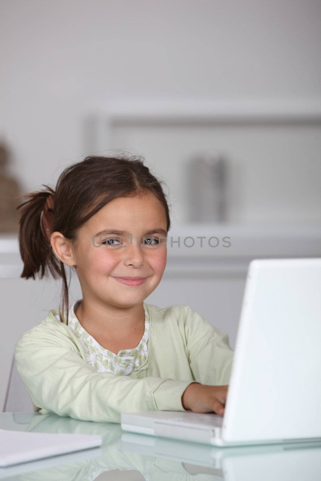 Little girl sat with laptop computer