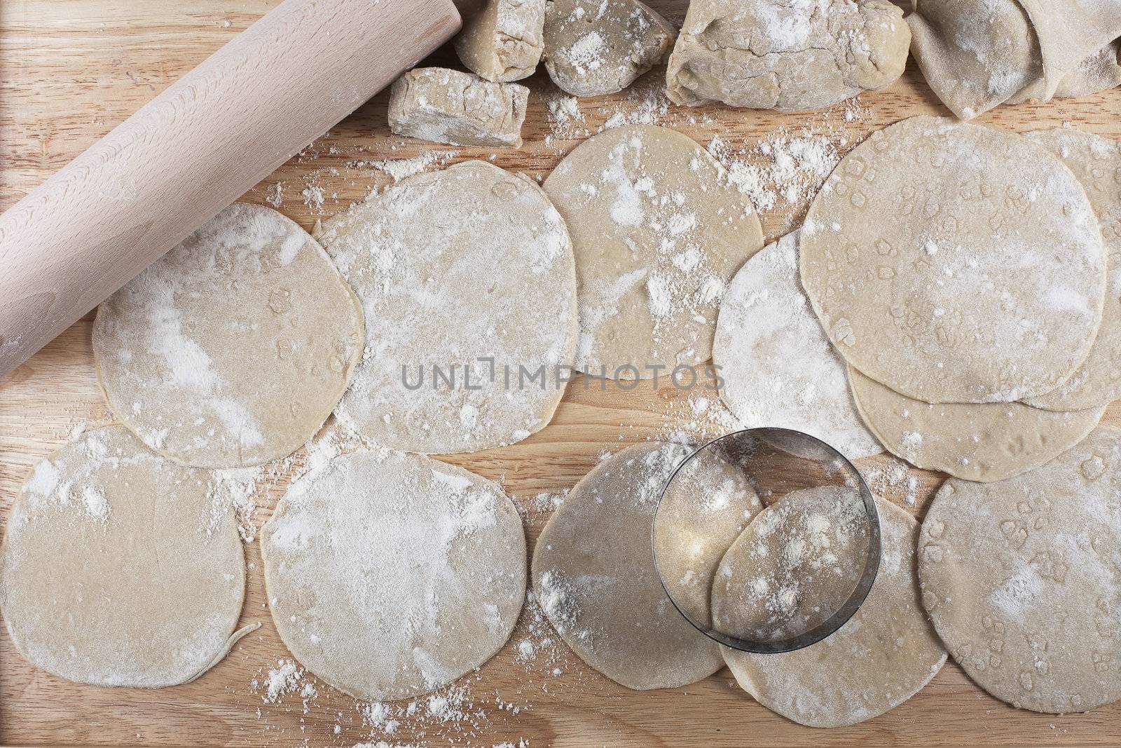 Homemade dough rolled out into circles for making potstickers.