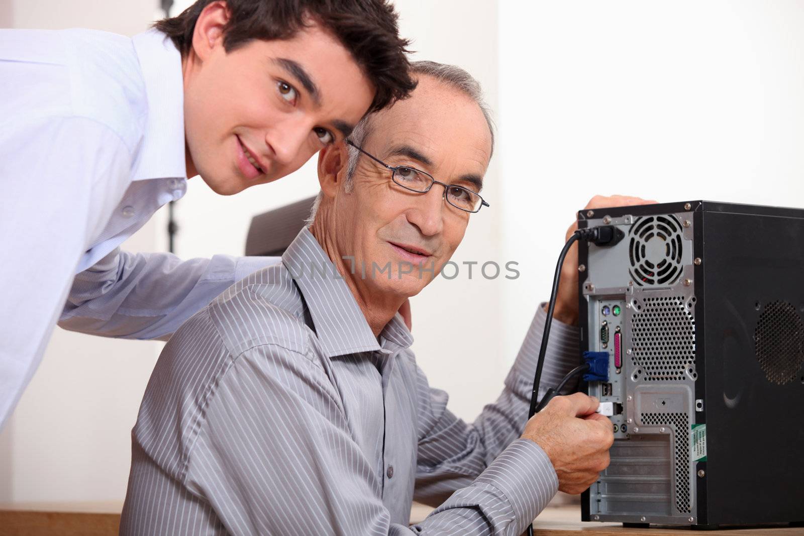 Father and son fixing a computer by phovoir