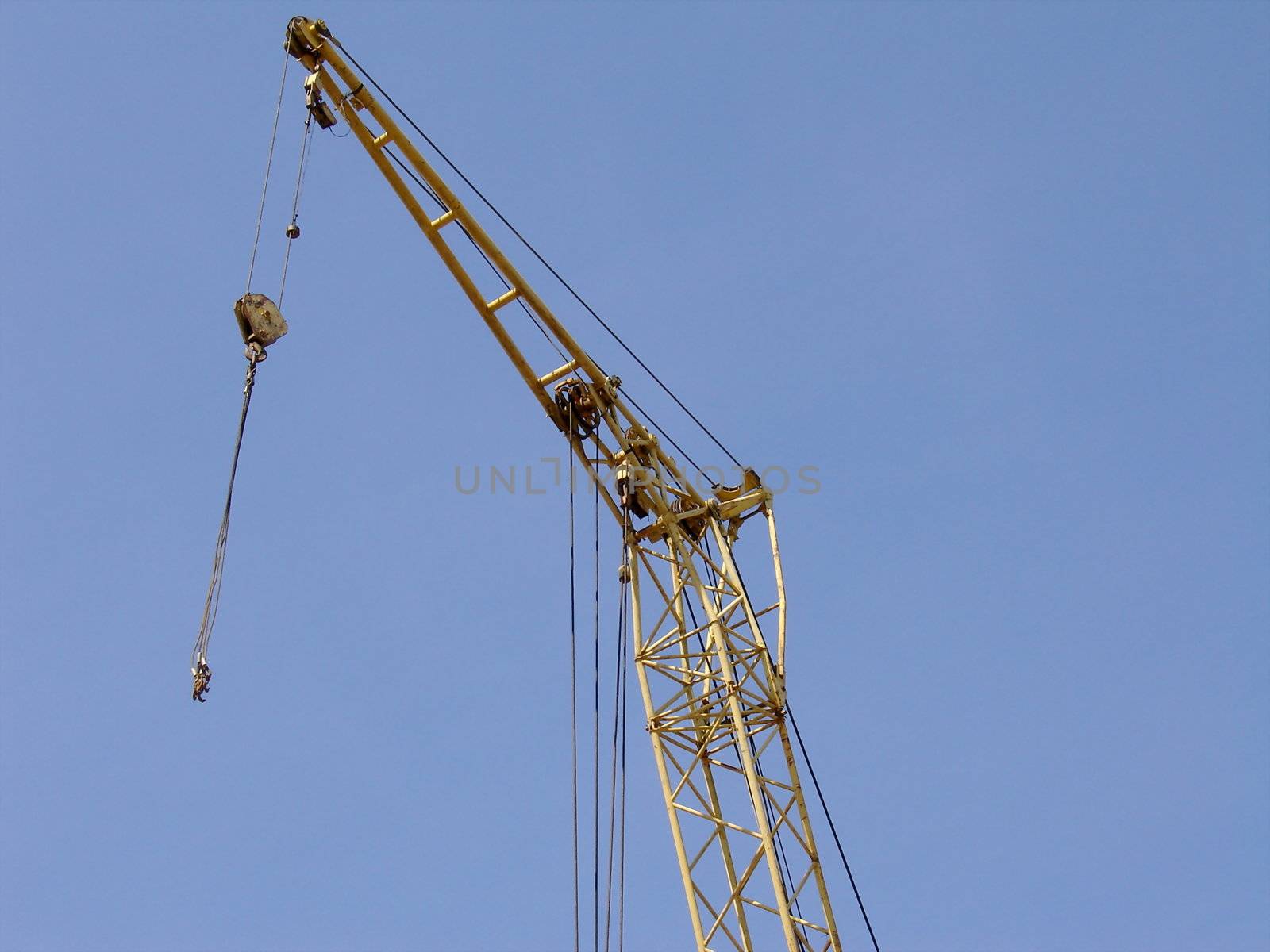 Industrial yellow crane on a background of blue sky