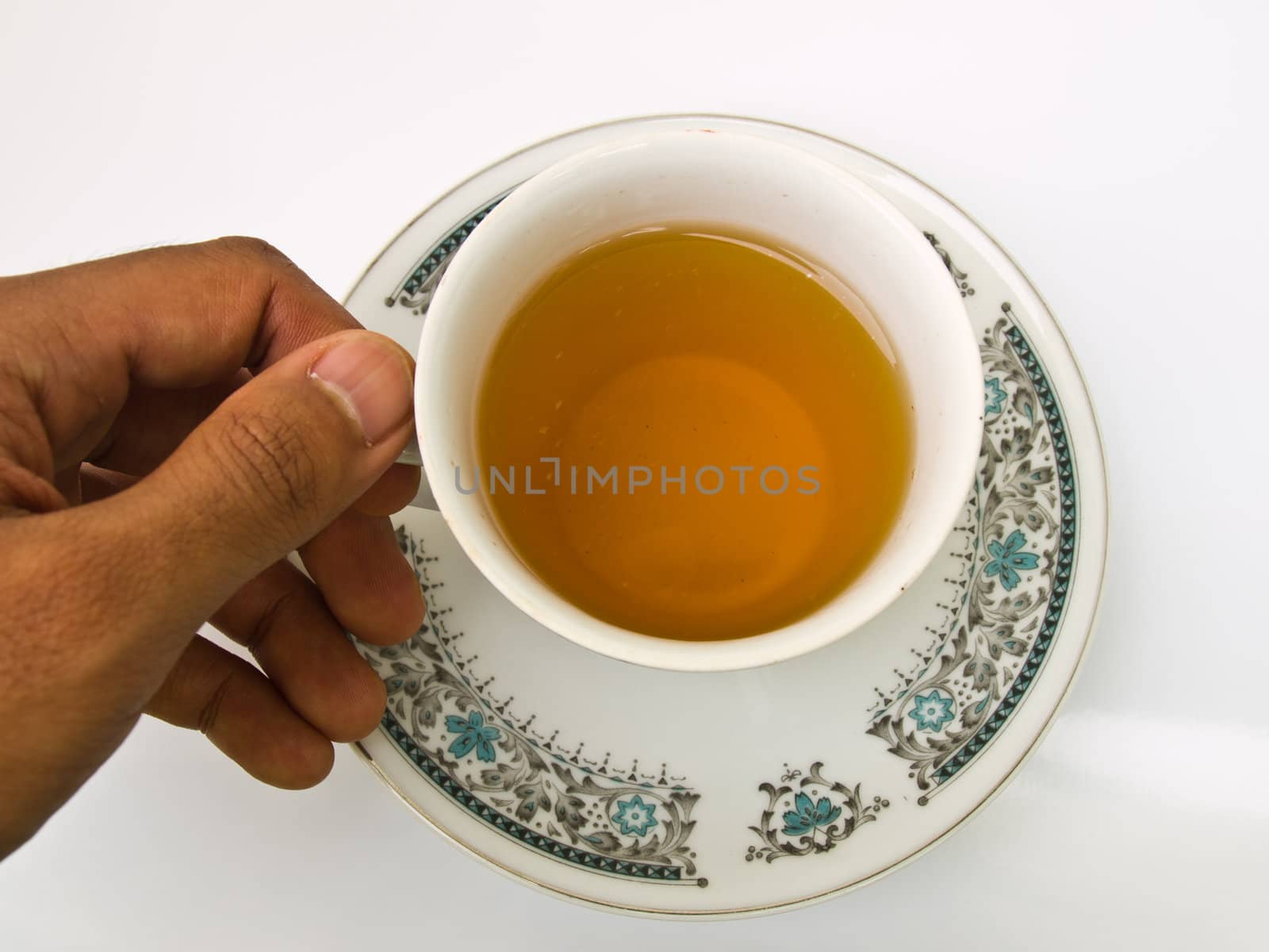 A cup of tea with floral pattern holded by hand isolated on whit by gururugu