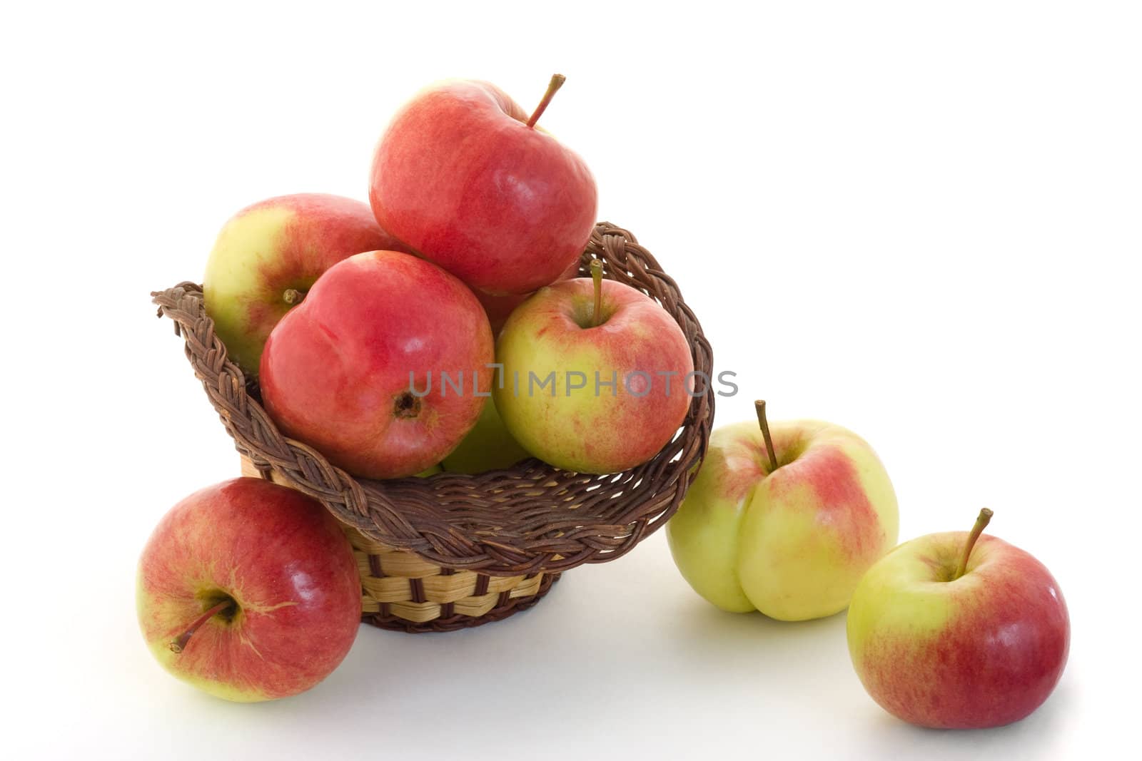 Ripe apples in a basket on a white background