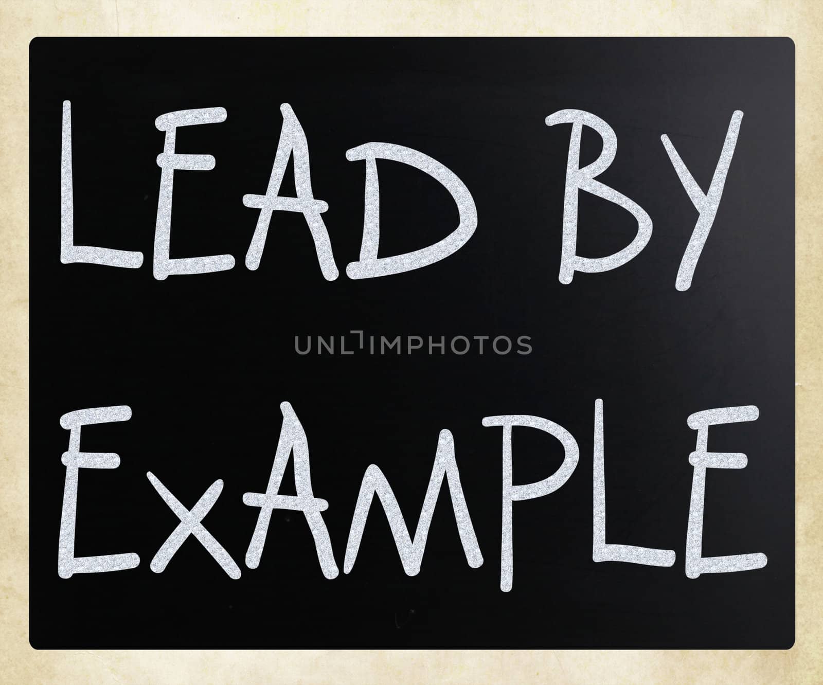 "Lead by example" handwritten with white chalk on a blackboard
