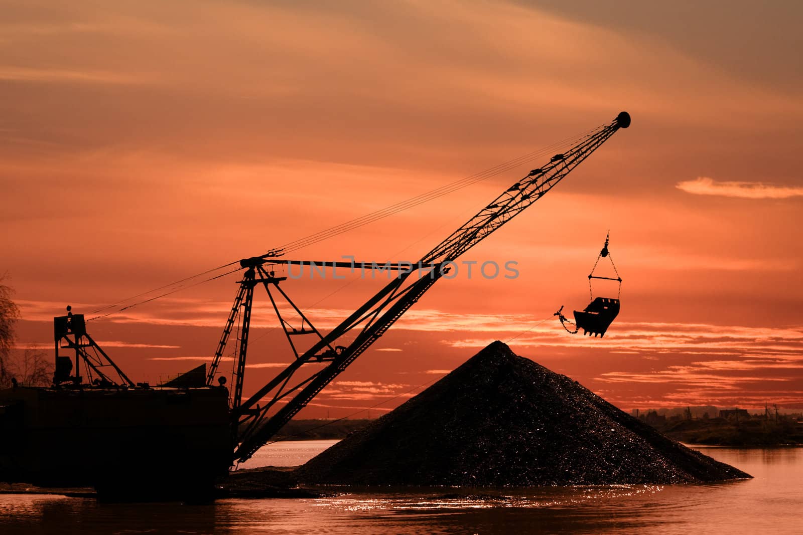 Silhouette of a career dredge on a background of an evening dawn