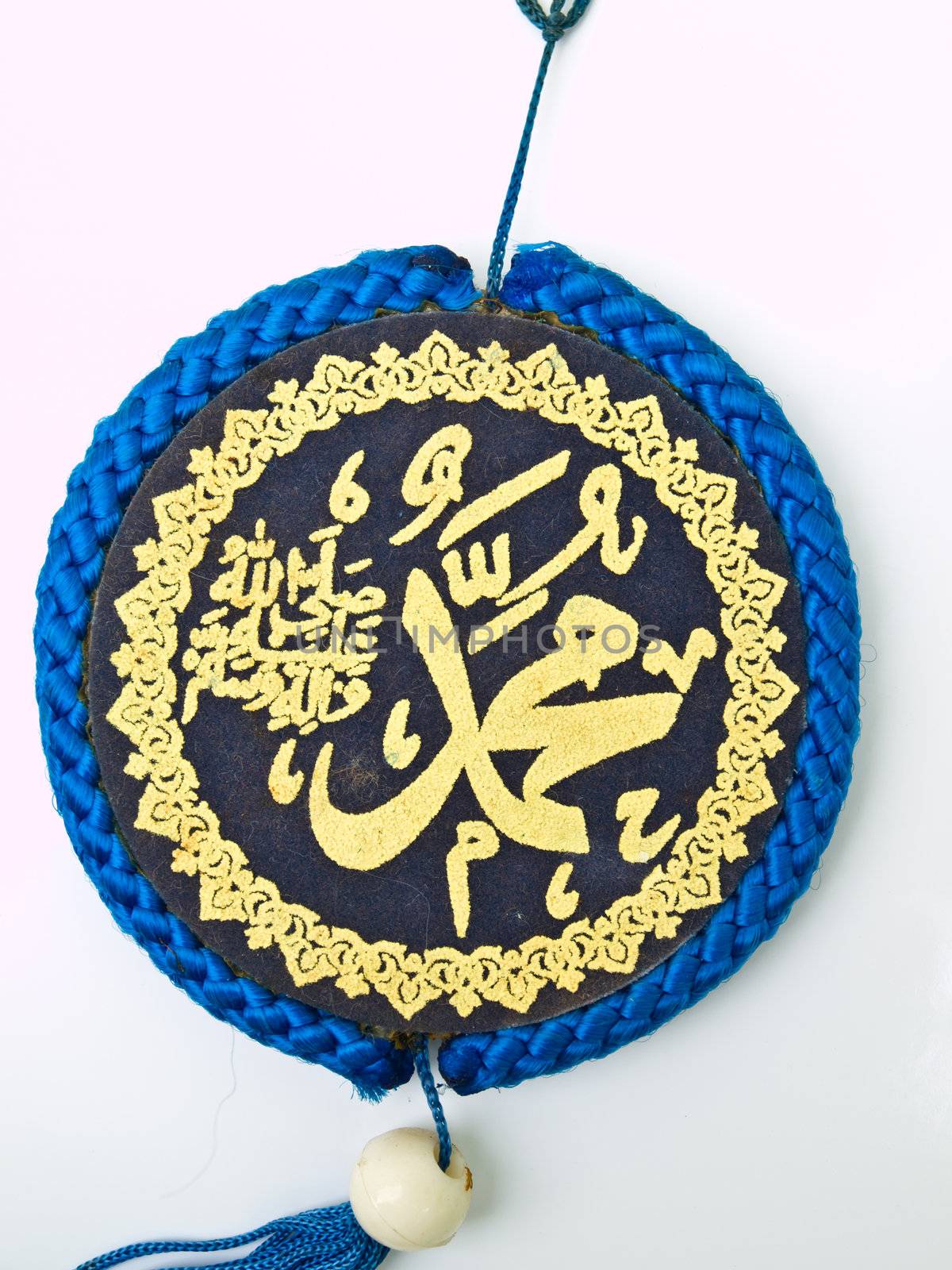 Clos up of blue velvet Allah pendent isolated on white background Islamic calligraphy transliterated as 'Muhammad Rasulullah' (which mean Muhamad is the messenger of God)