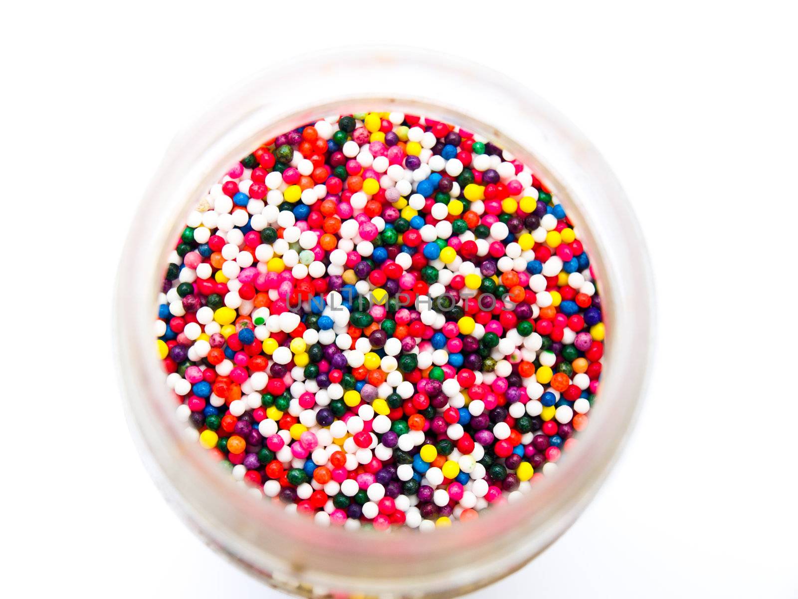 Sugar sprinkle dots in a bottle isolated in white background from topview