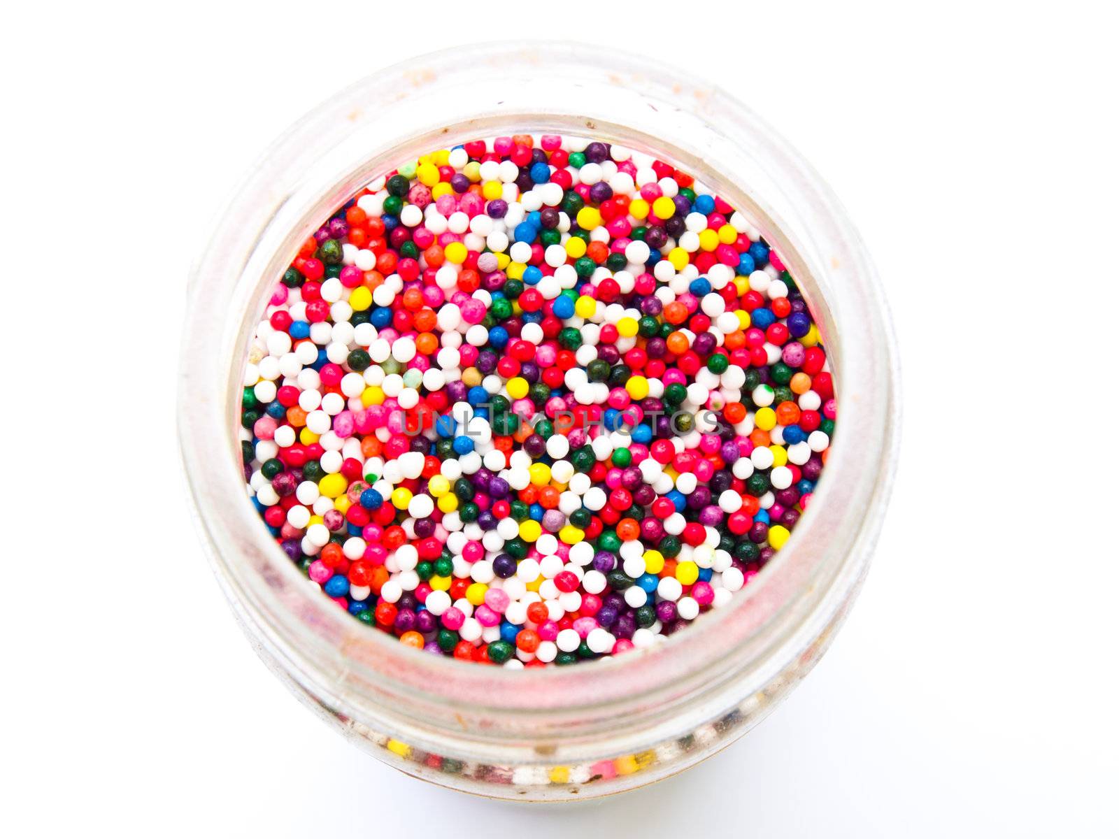 Sugar sprinkle dots in a bottle isolated in white background from topview