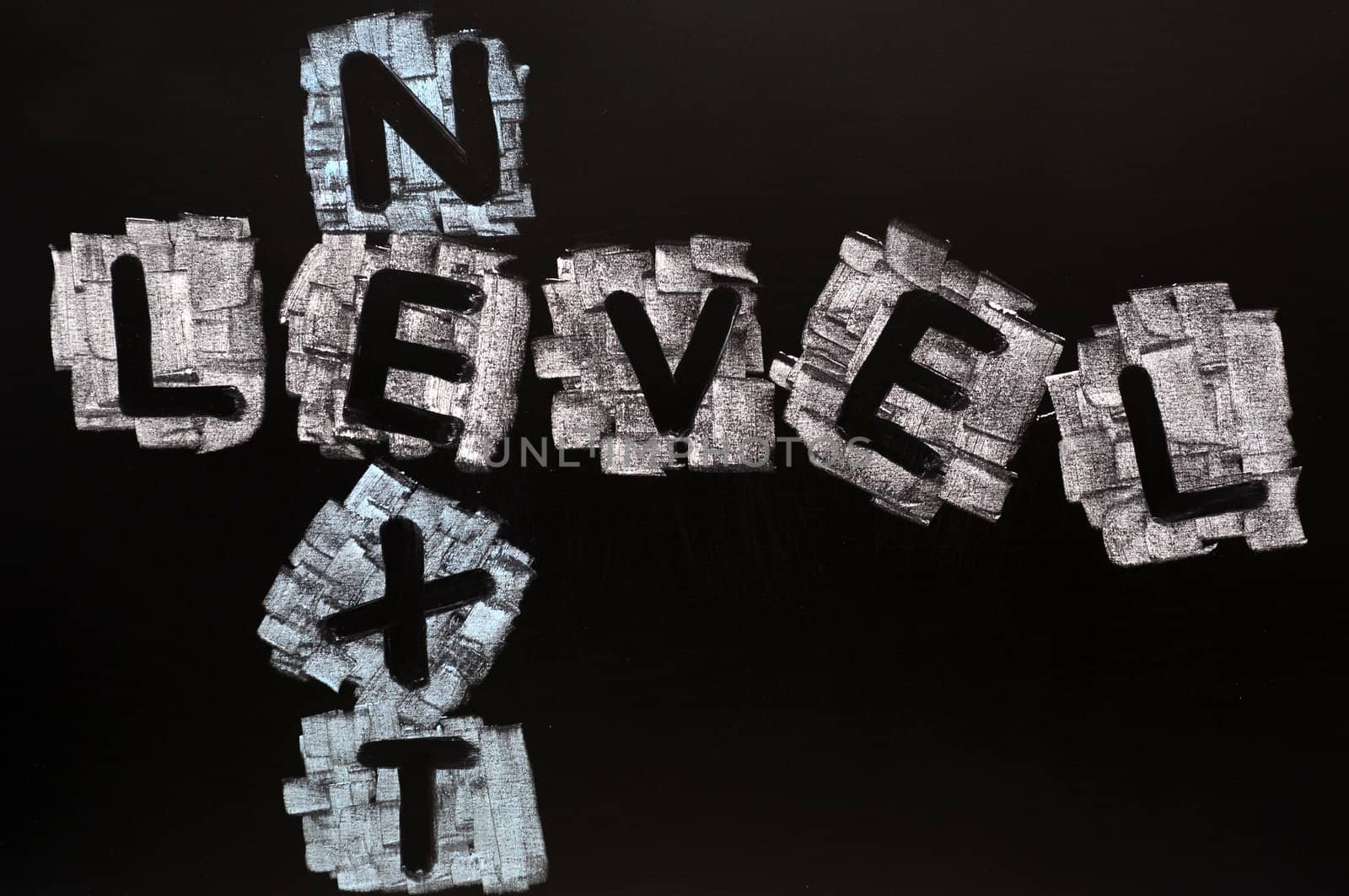 Crossword of Next Level written in chalk on a blackboard