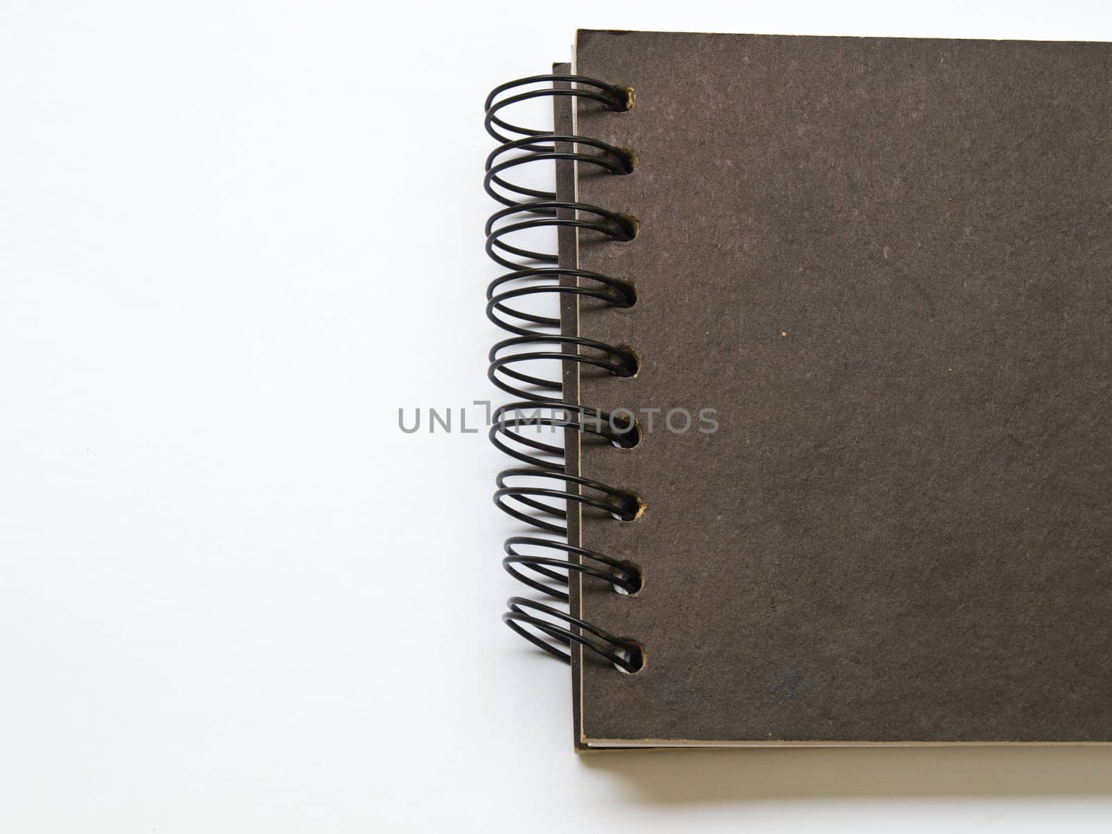 A black spiral binding notebook on white by gururugu