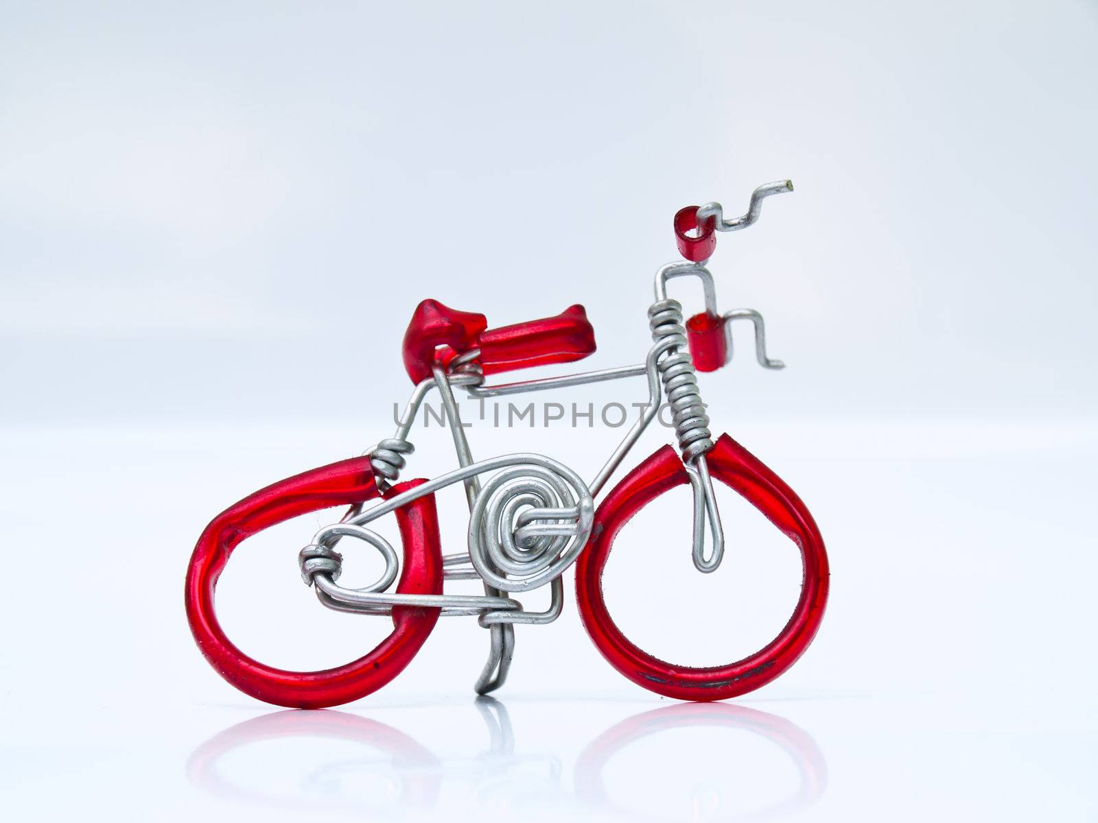 A miniature red bicycle isolated on white background in profile by gururugu