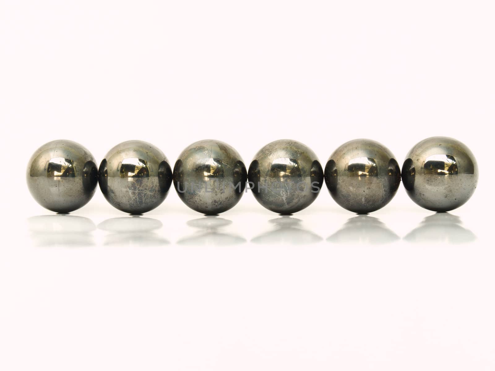 Line of iron metal balls isolated on white background by gururugu