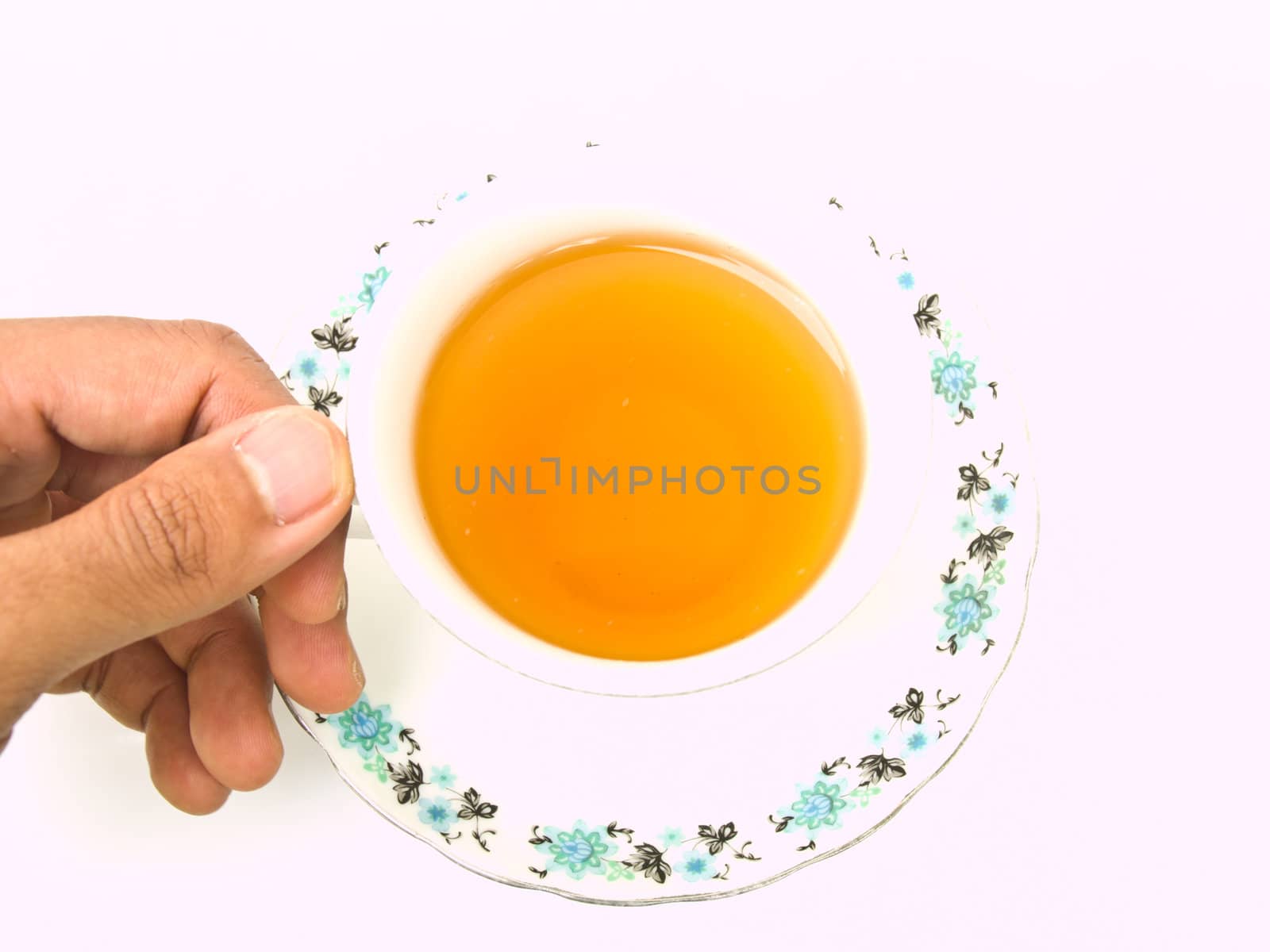 A cup of tea with floral pattern holded by hand isolated on whit by gururugu