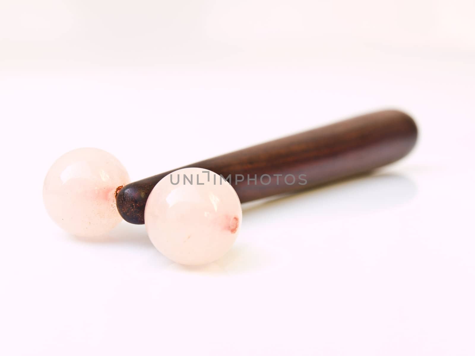 Wooden facial massage stick isolated on white background by gururugu