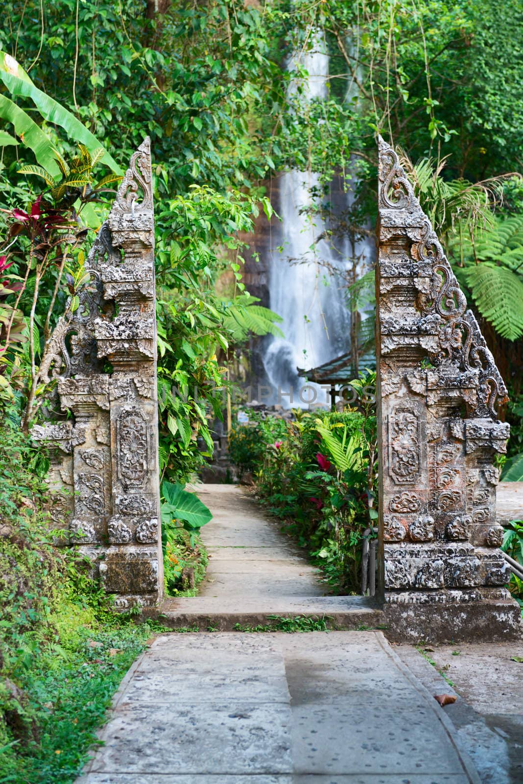 Traditional double stone gate on waterfall by iryna_rasko