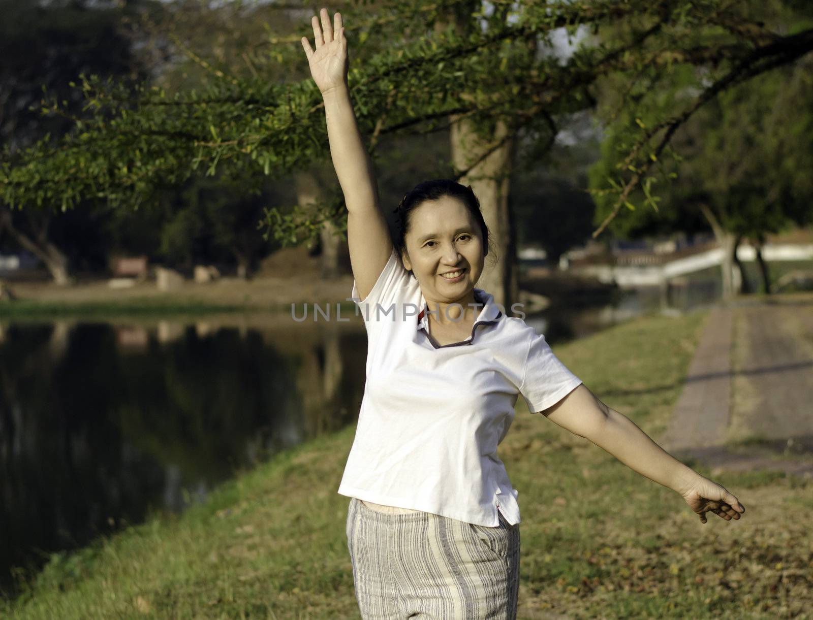 Woman doing morning exercises in the park  by siraanamwong