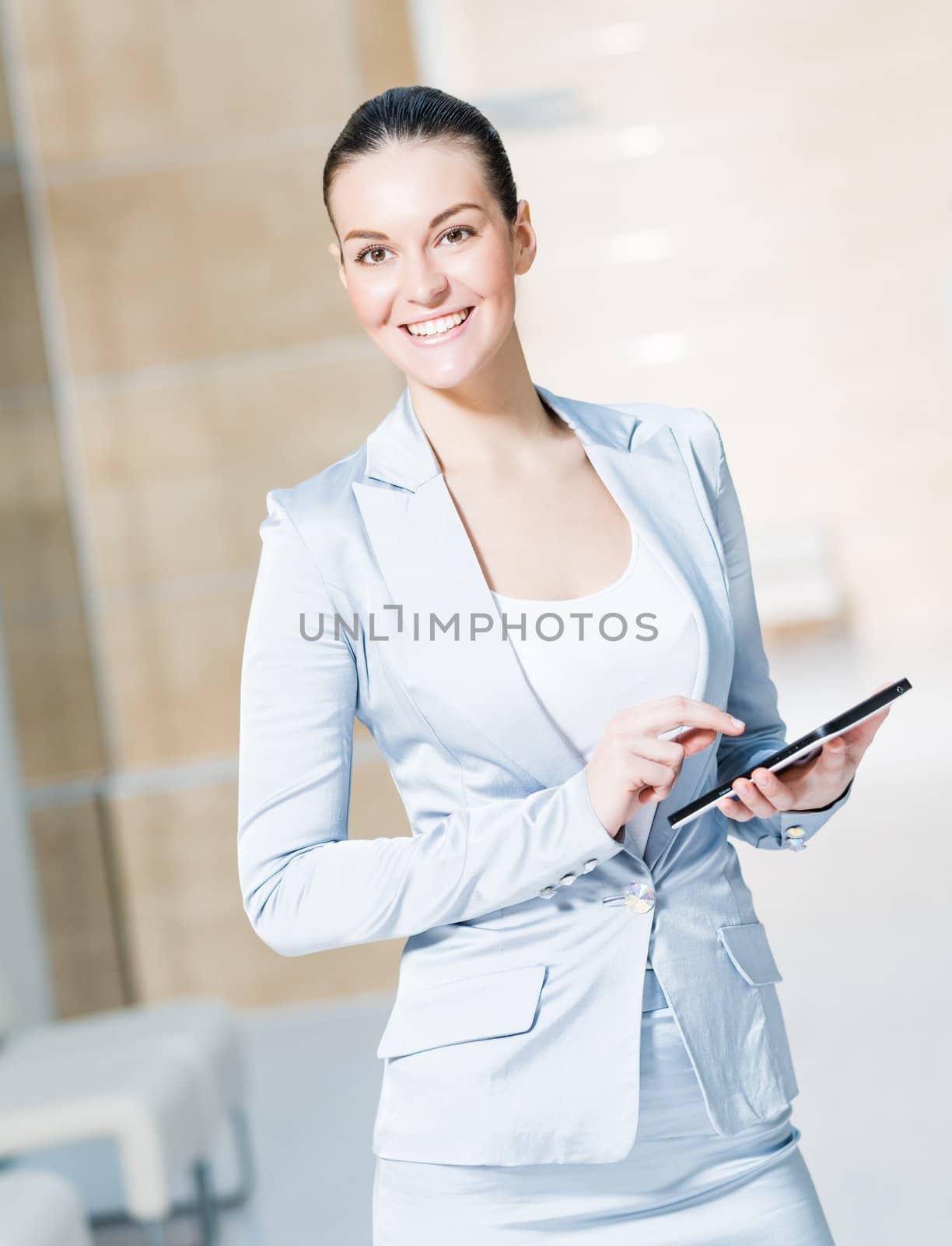 Portrait of a business woman in the tablet at the office, turned around and looking at the camera