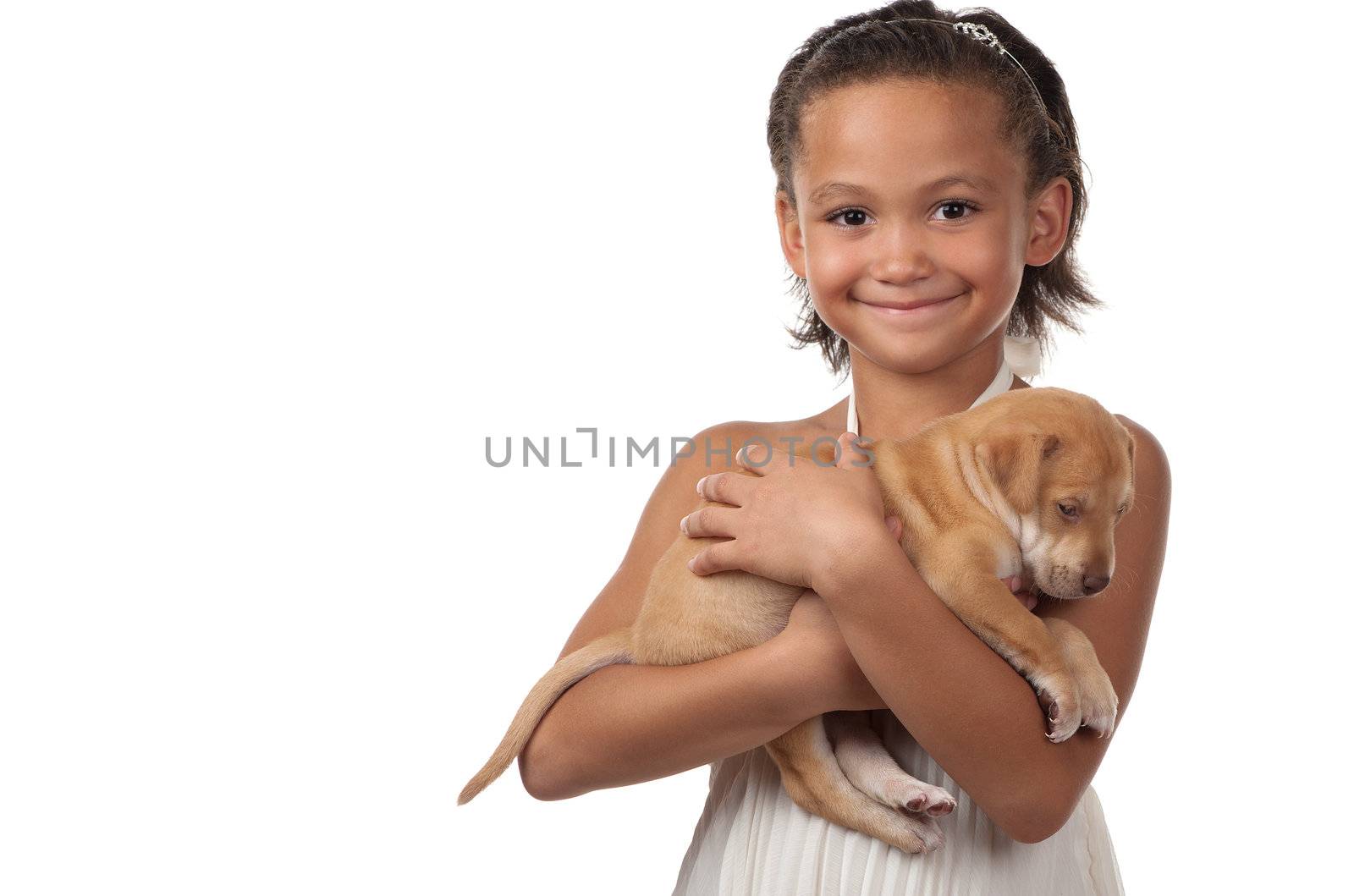 A little girl happily cuddles her little puppy.