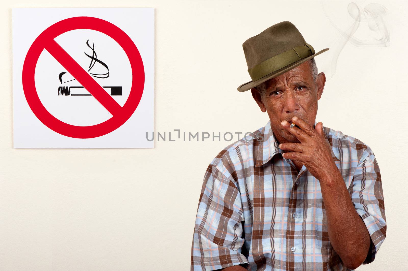 A senior citizen pays scant regard to a non-smoking sign.