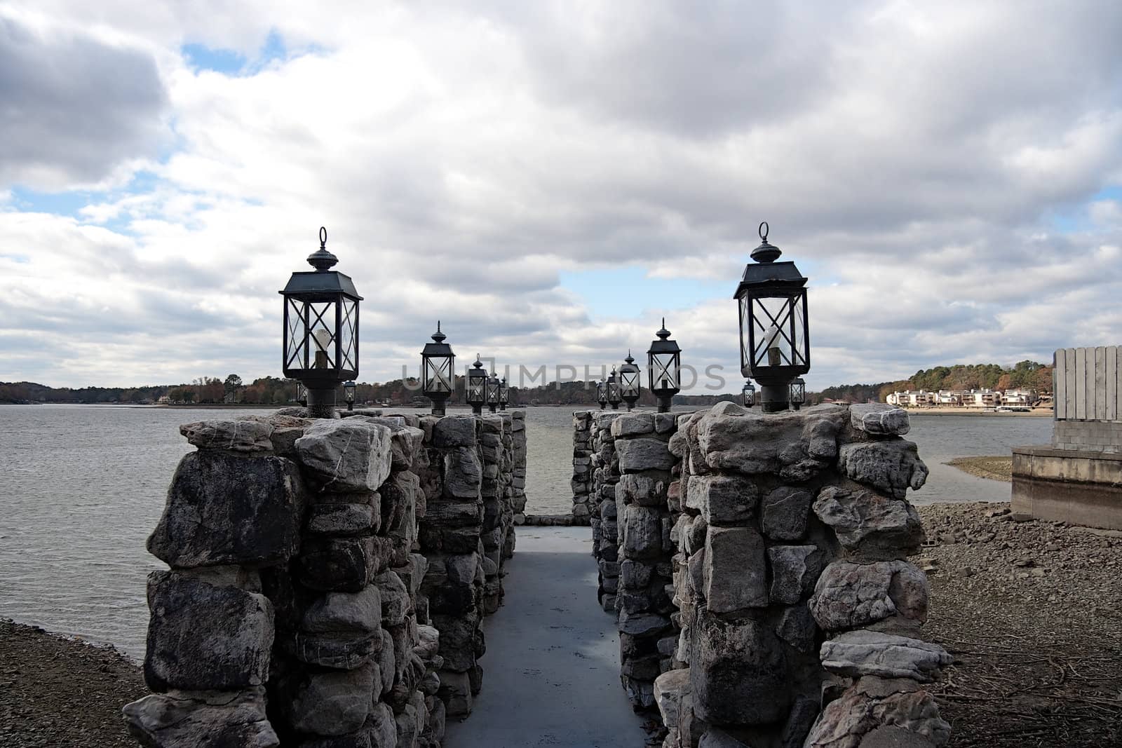 A dock made out of stone leading to the water.