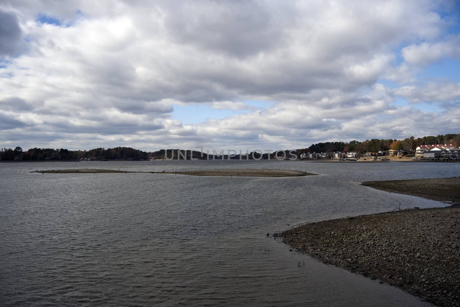 A low water lake with calm waters and cloudy sky