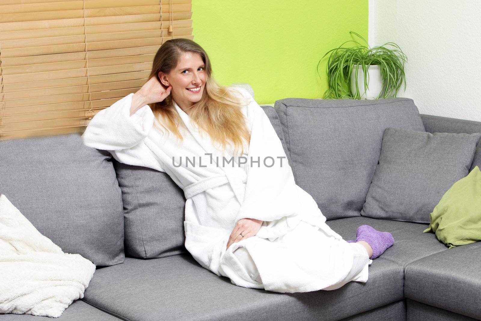 Smiling woman sitting on a couch looking at the camera