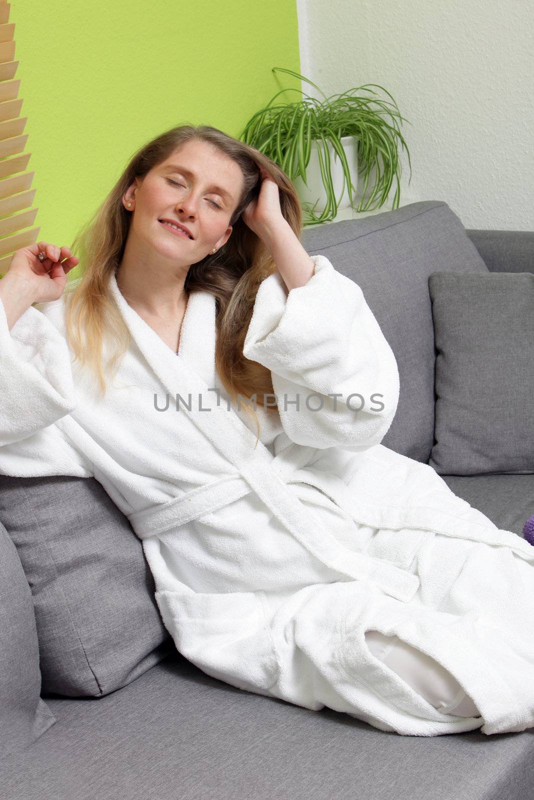 Portrait of relaxed woman touching her hair with closed eyes