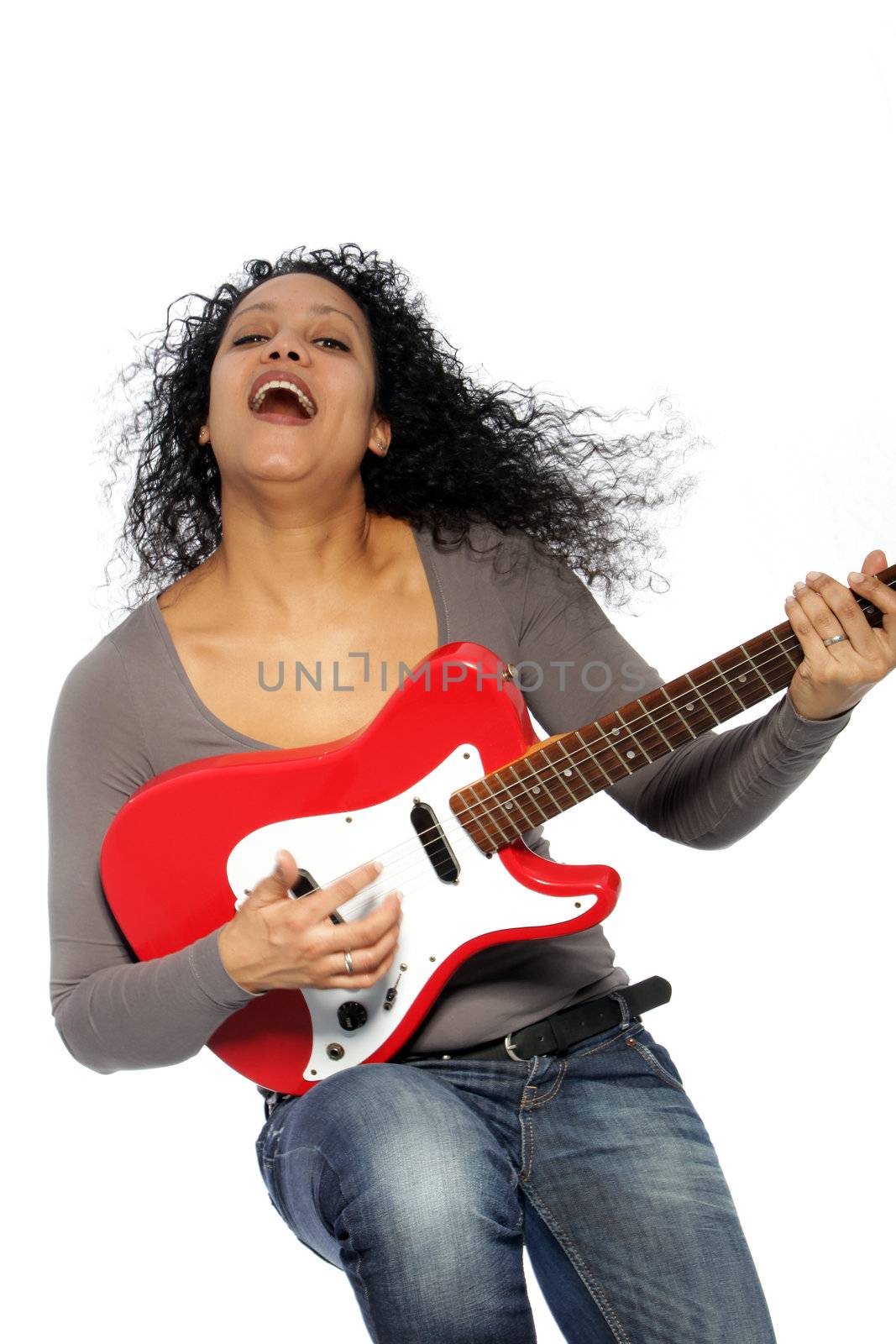 Woman with curly hair playing guitar and singing