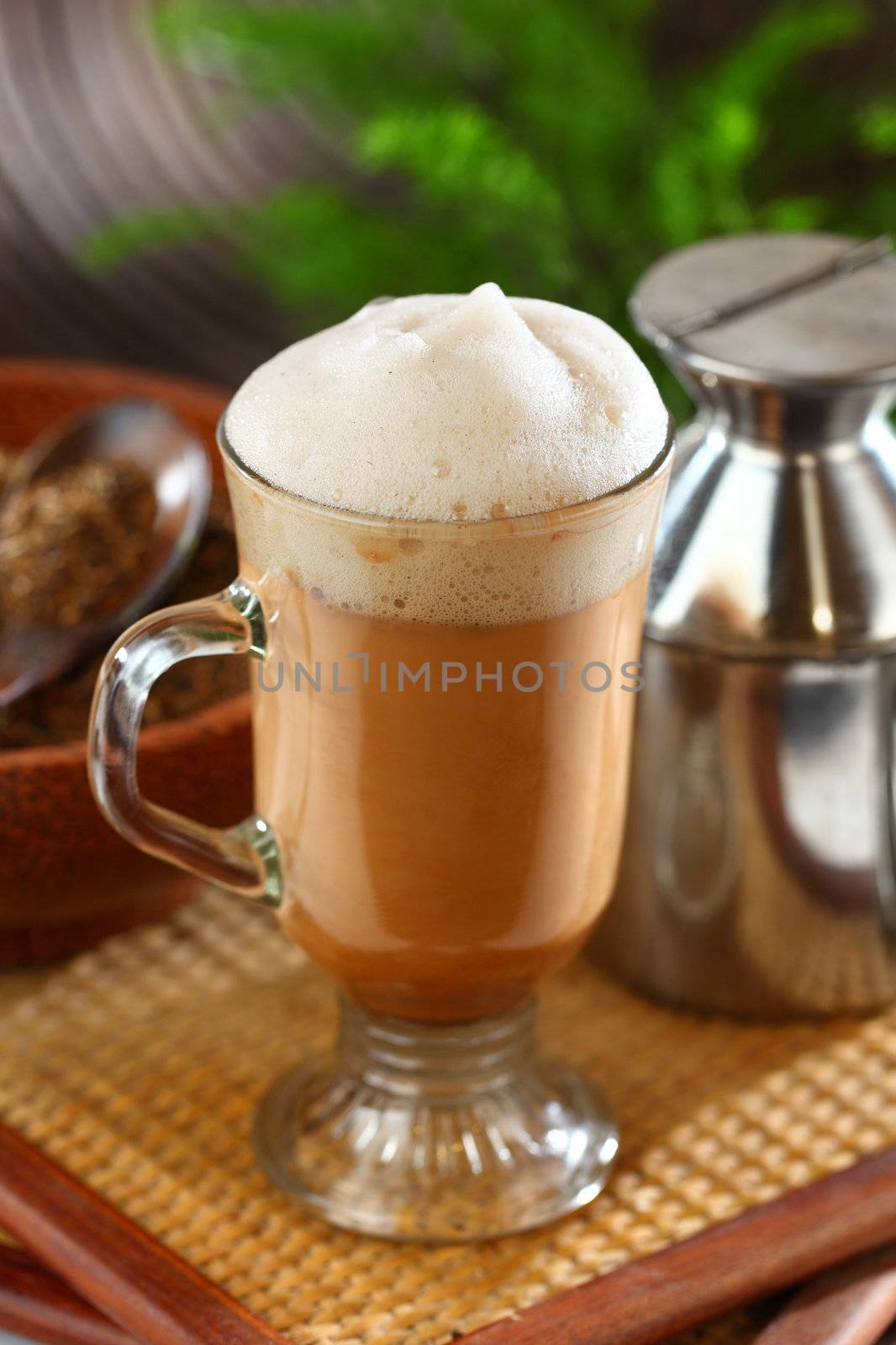 Malaysian famous teh tarik, "pulled tea", flavored hot tea beverage. Its name is derived from the pouring process of "pulling" the drink during preparation